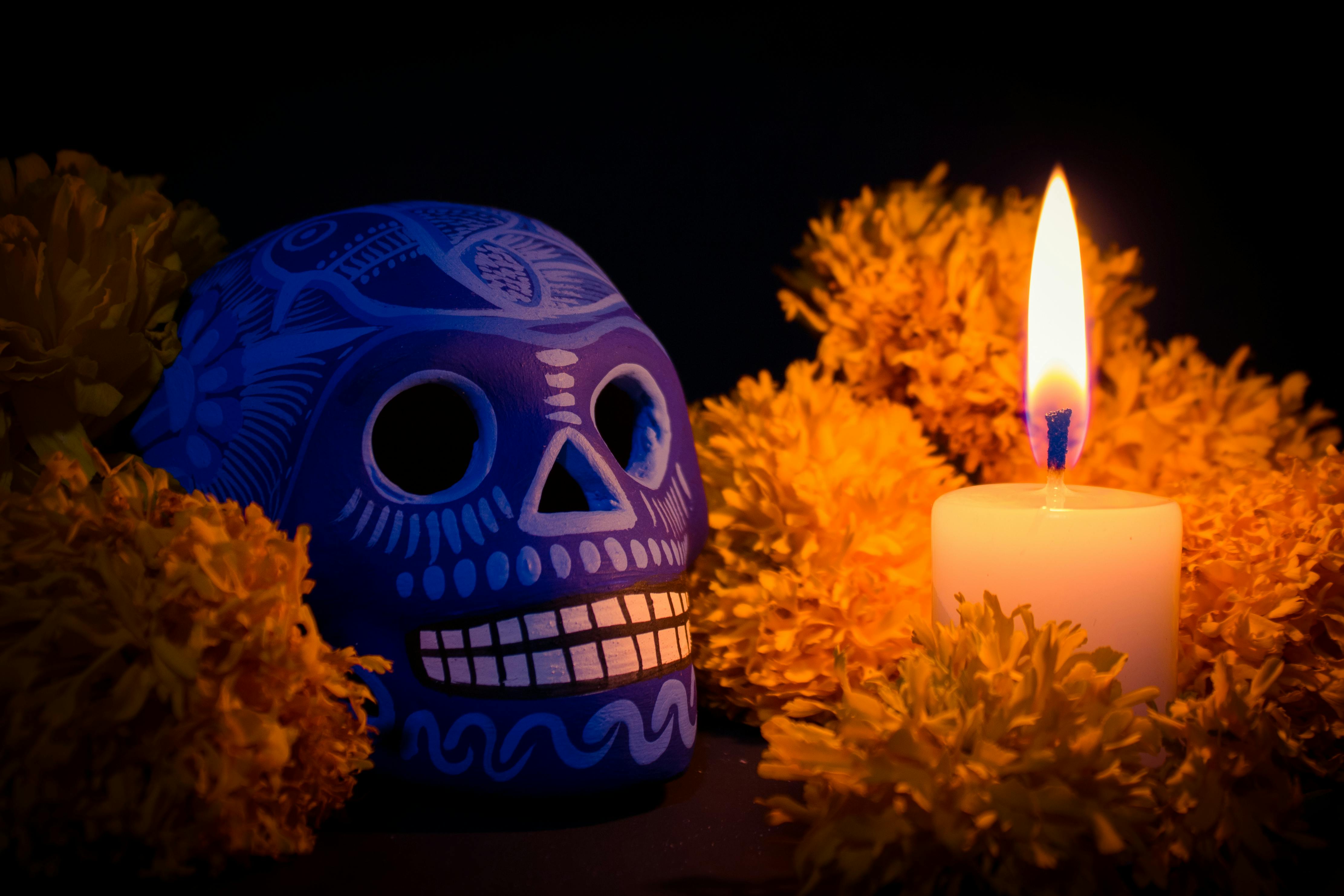 Mixquic, tradición intacta con calavera de talavera azul y vela entre cempasúchil